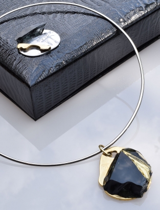 Girocollo in argento (Ø 15 cm). Gioiello (4x4,5x1 cm) cristallo e bronzo. Cofanetto con logo e richiamo del gioiello.